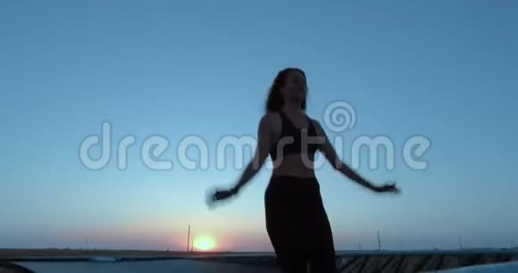 一个女孩在蹦床上跳得很高对着天空积极的生活方式视频的预览图