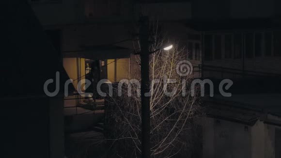 一个柱子上的灯笼在房子附近的夜晚发光有人离开入口视频的预览图