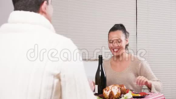 坐在桌边和丈夫一起享用圣诞大餐的女人视频的预览图