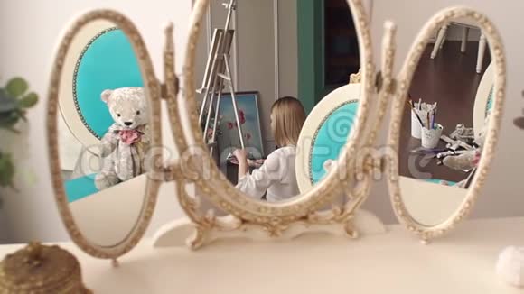 这位艺术家画室里的一面老式镜子里的女孩的倒影视频的预览图