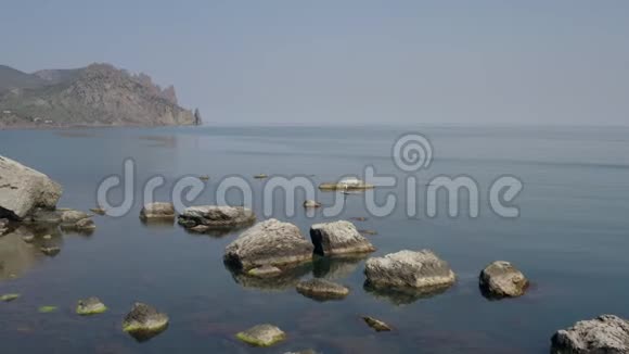 从海岸看海景近岸水中伸出的大块巨石视频的预览图