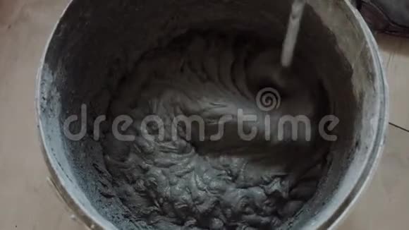 胶水混合物在桶里灰色胶水溶液由工人混合在桶中视频的预览图