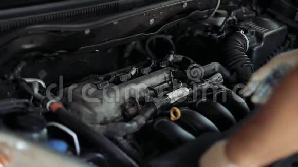 一名男性汽车修理工检查汽车发动机的油位视频的预览图
