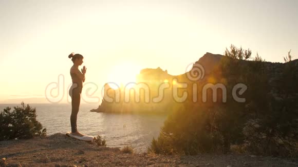 女人在日落时在海边做瑜伽视频的预览图