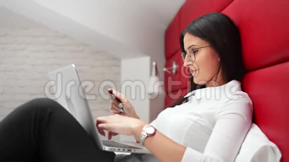 笑容可掬的商务女性享受网上购物用信用卡进行电子支付视频的预览图