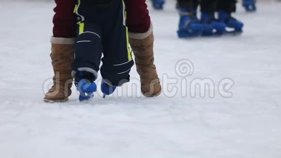 在父母的大力帮助下小孩子在冰上滑冰慢动作视频的预览图