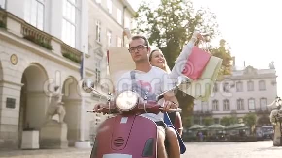 一对年轻貌美的夫妇在城市街道上骑着摩托车快乐的女人举起手来买东西视频的预览图