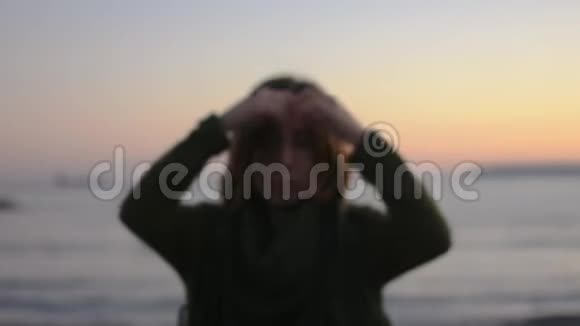日落时海滩上一位年轻女子的肖像她玩得很开心慢动作视频的预览图