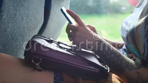 智能手机在乘坐公共交通工具的女孩手中视频的预览图