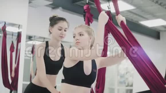 反重力瑜伽体育女孩在健身房的艾罗约加与一名教练订婚视频的预览图