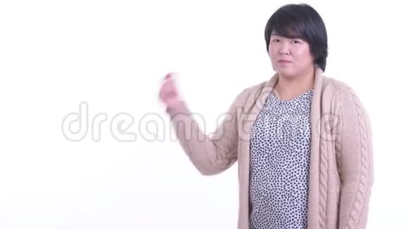 快乐超重的亚洲女人亲吻手指展示冬天的东西视频的预览图