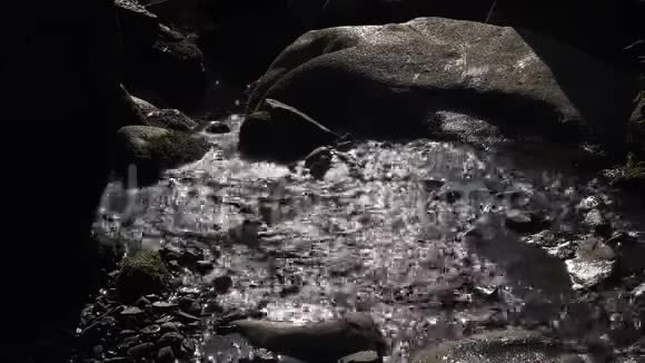 小溪流在大岩石之间山景中有背光视频的预览图