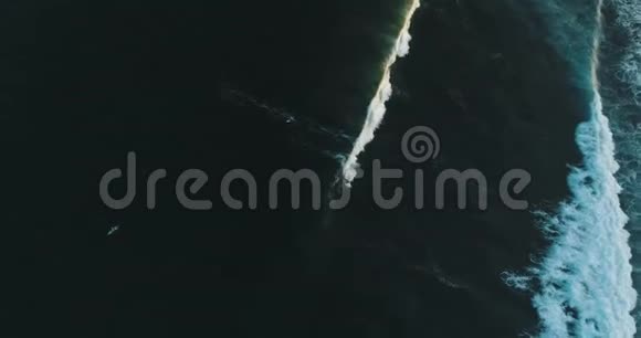 在晴朗的蓝色天气里空中追踪拍摄于一位熟练的男性冲浪者在海浪中乘风破浪视频的预览图