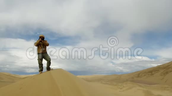 在戈壁逃兵的沙丘上拍照的游客视频的预览图