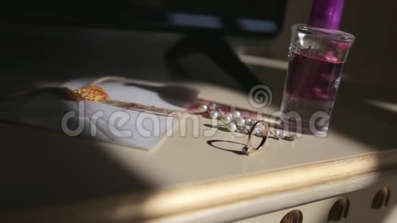 婚礼前的戒指和香水摆在桌子上视频的预览图