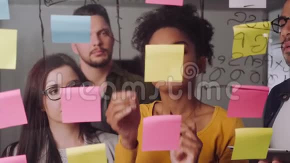 自信的年轻女企业家和她的同事在一块玻璃板上讨论商业想法和计划视频的预览图
