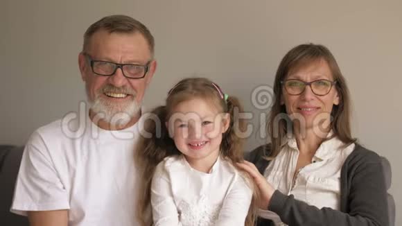 家庭世代和人的概念快乐的微笑祖母祖父和小孙女拥抱公园视频的预览图