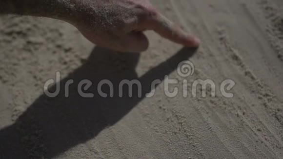 近距离射击一名男子手触摸沙滩慢动作现实生活视频的预览图
