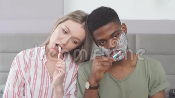 多种族的困倦夫妇坐得很近早上刷牙视频的预览图