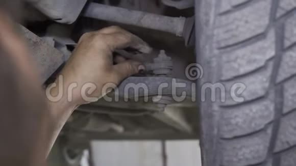 机械师在汽车特写的底盘上更换靴子视频的预览图