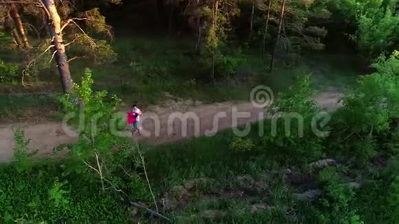 一对相爱的情侣在树林中奔跑的俯视图视频的预览图