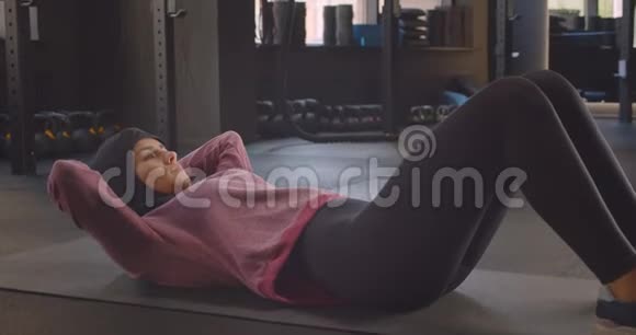 年轻坚定的穆斯林女性戴着头巾在健身房锻炼的特写镜头视频的预览图