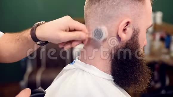 剪下的男理发师用刷子和剃头颈除头发用电动剃须刀刮胡子客户的头视频的预览图