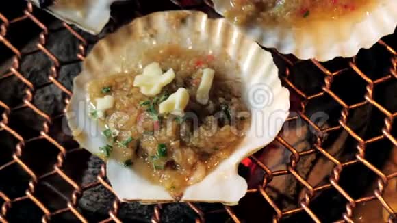 大型新鲜扇贝壳海鲜烤架上金属网上木炭烧烤在韩国餐厅烧烤烹饪风格视频的预览图