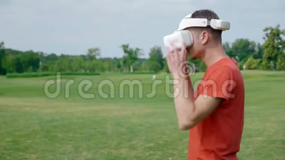 公园里一个头戴VR耳机的男人看着摄像机笑了视频的预览图