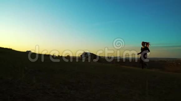 日落时分女孩和美国斯塔福德郡的猎犬在空中穿行视频的预览图