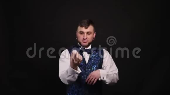 魔术师在黑暗背景下用白色球表演魔术视频的预览图