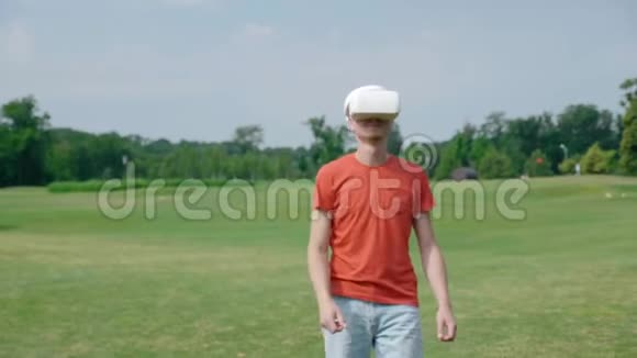 一个男人在公园里用VR耳机回来说话微笑视频的预览图