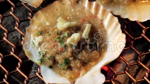 大型新鲜扇贝壳海鲜烤架上金属网上木炭烧烤在韩国餐厅烧烤烹饪风格视频的预览图