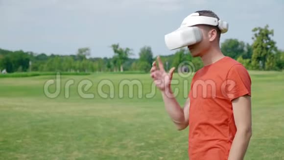 一个男人在公园里用VR耳机纠正它视频的预览图
