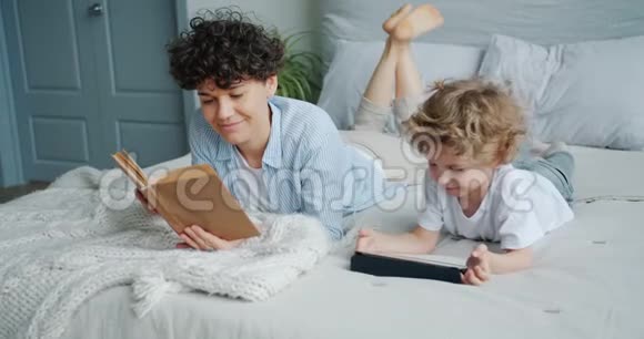 妈妈在卧室看书的时候孩子在看动画片视频的预览图