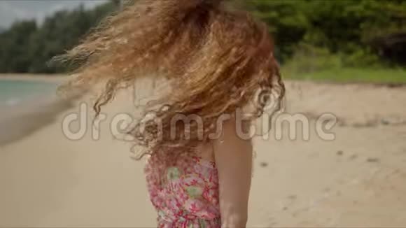 自信的女人在沙滩上挥舞着头发看着镜头视频的预览图