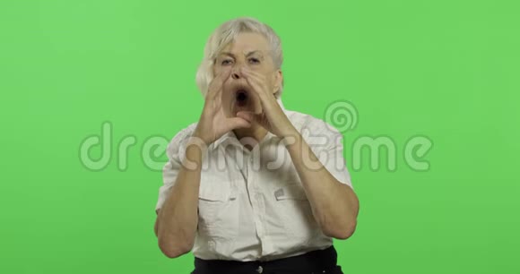 一位老年妇女用手喊叫和挥手老奶奶笑了铬键视频的预览图