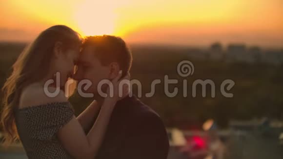 在日落时分恋人们在屋顶上互相对视屋顶上的浪漫情侣视频的预览图