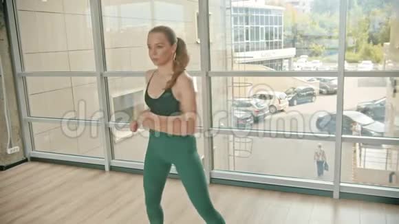 一位运动女拳击手站在窗边打拳击训练她的拳打脚踢视频的预览图
