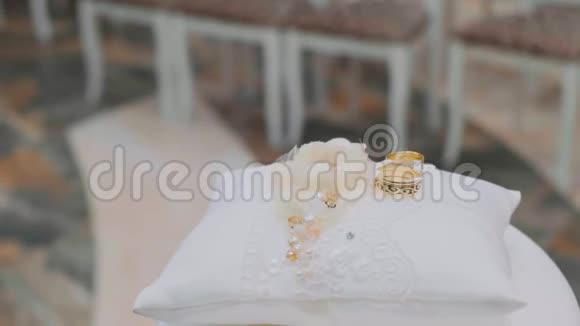 白色枕头上的结婚戒指婚礼的概念两枚金戒指视频的预览图