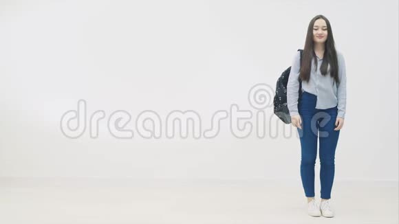 美丽的微笑亚洲青少年高中生穿着蓝色牛仔牛仔裤和衬衫学校背包翻过来视频的预览图