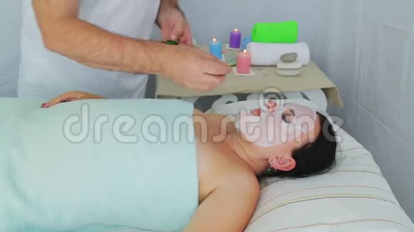 一位男性美容师在一家水疗沙龙里给一位女性客户做蔬菜疗法视频的预览图