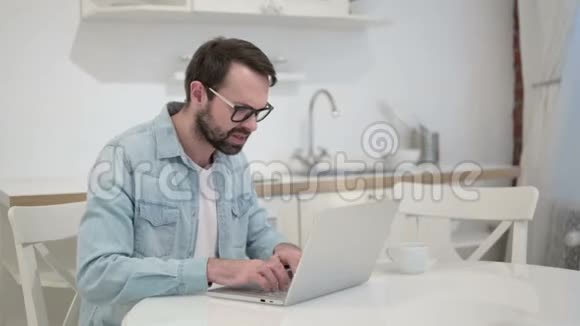 办公室里焦急的胡子年轻人在笔记本电脑上生气视频的预览图