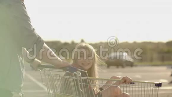 年轻浪漫的一对夫妇在晚上玩超市手推车英俊的胡子男和迷人的年轻视频的预览图