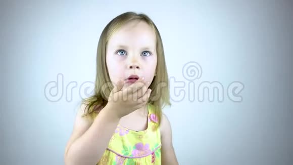 一个三岁的小女孩咳嗽用手捂住嘴在白色背景下视频的预览图