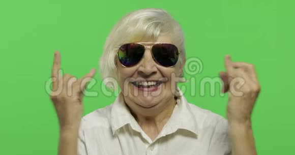 一位老年妇女用手和舌头显示出角的迹象视频的预览图