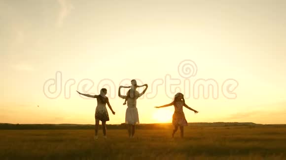 快乐的童年概念幸福的年轻家庭带着一个孩子在日落时分的飞行中跑过田野母亲和视频的预览图