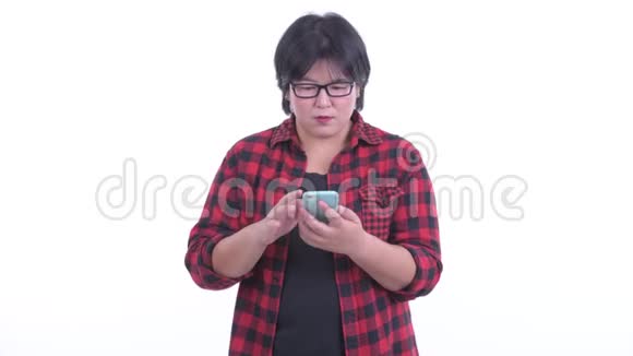 快乐超重的亚洲时髦女人使用电话得到好消息视频的预览图