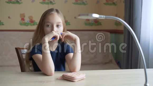 体贴的少女坐在书桌前手拿笔思考视频的预览图