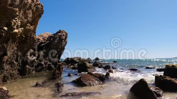夏天海浪海岸带着石头和岩石来到海滩视频的预览图